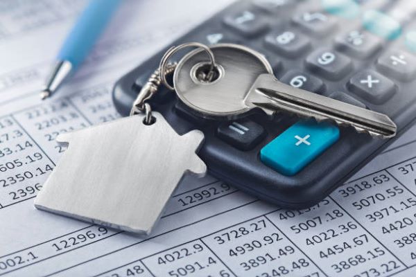 Casas en venta en Metepec; unas llaves con el llavero de una casa sobre una calculadora